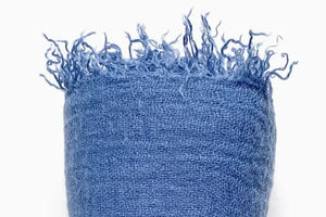 Blue textured fabric with frayed edges on a white background