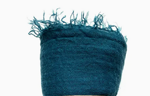 Blue textured fabric with frayed edges on a white background
