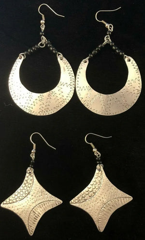 Pair of silver hoop earrings and pair of silver star-shaped earrings on a black background