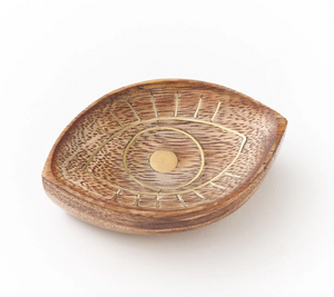 Wooden dish with eye design on a white background