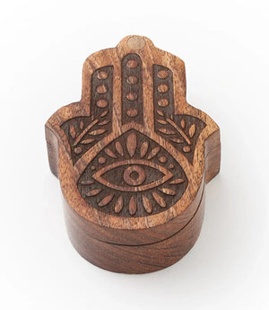Wooden Hamsa hand with eye design on a white background