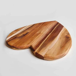 Wooden heart shaped cutting board on a light gray background