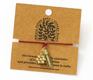 Bracelet with charms on a brown card with text and branding