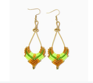 Pair of beaded earrings with green, tan and gold on a white background