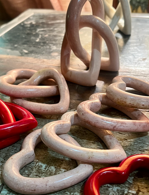 Pink and red ceramic rings on a textured surface
