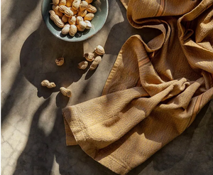 Peanuts on a stone surface with a folded yellow cloth