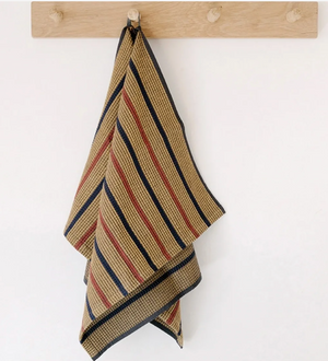 Striped yellow towel hanging on a wooden rack against a white background