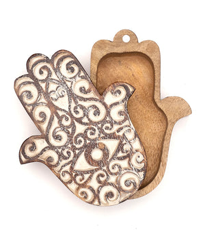 Wooden Hamsa hand with intricate carvings on a white background