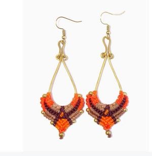 Pair of beaded earrings with orange, brown, and gold colors on a white background