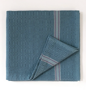 Blue patterned towel with a striped edge on a white background