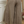 Person wearing brown linen pants standing in a room with a mirror and decorative items.