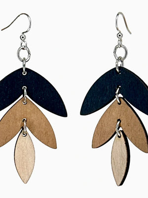 Pair of earrings with layered wooden leaves on a white background