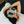 Person lying on a couch with a green striped eye mask on, wearing a white shirt.