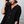 Woman wearing a black henley shirt with a neutral background