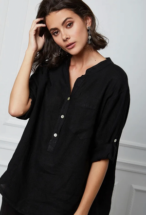Woman wearing a black henley shirt with a neutral background