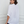 Woman wearing a white henley shirt against a white background