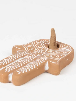 Decorative ceramic hamsa hand with white patterns on a white background