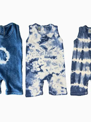 Three tie-dye baby rompers in blue and white on a white background