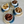 Four bowls with nuts on woven coasters on a light surface