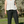 Person wearing a white sleeveless top and black pants standing in a natural setting.