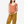 Woman wearing a striped orange top and brown pants on a white background