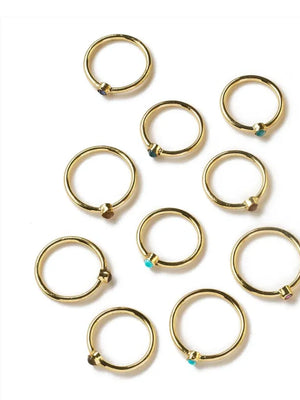 Gold rings with small gemstones on a white background