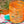 Orange glass with decorative pattern on a colorful fabric background