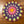 Colorful crocheted mandala mat on a wooden floor