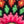 Close-up of a colorful woven pattern mandala with pink, green, and orange colors.