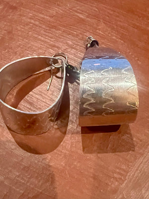 Silver and gold earrings on a wooden surface