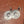 Pair of silver earrings with sunburst design on a wooden surface