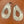 Silver teardrop earrings with intricate patterns on a brown surface