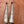 Pair of silver cone-shaped earrings with tribal patterns on a wooden surface