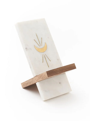 Marble and wood phone stand with gold moon design on a white background