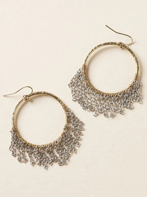 Pair of gold and silver hoop earrings on a beige background
