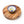 Wooden round cheese board with a ceramic bowl featuring blue and yellow patterns on a white background