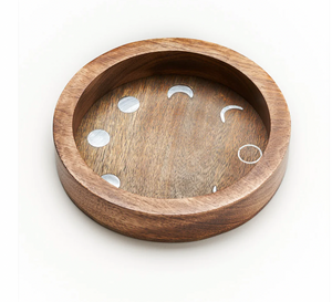 Wooden tray with moon phase cutouts on a white background