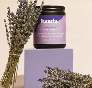 Kandu lavender cypress candle with lavender sprigs on a beige background
