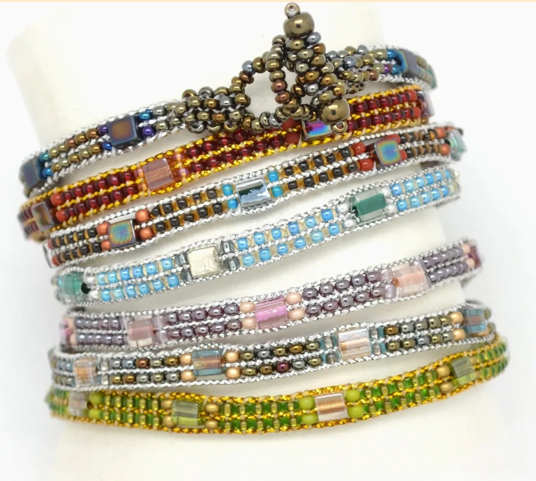 Stack of colorful beaded bracelets on a white background
