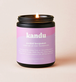 Kandu candle with a purple label on a beige background