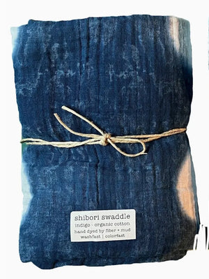 Shibori tie-dye swaddle with natural twine and a label on a white background