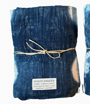 Shibori tie-dye swaddle with natural twine and a label on a white background