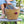 Person holding a woven basket tote bag with colorful pom-poms outdoors