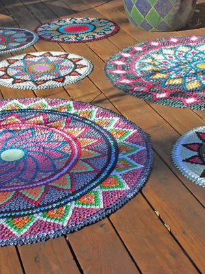 Colorful crocheted mandala rugs on a wooden floor