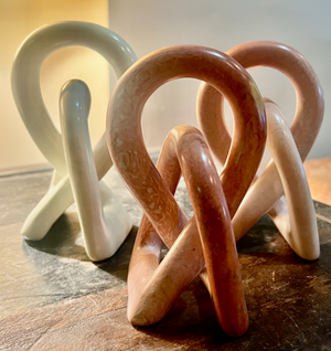 Set of ceramic sculptures in various colors on a wooden surface