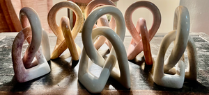 Set of ceramic sculptures in various colors on a wooden surface
