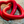 Red heart-shaped object on a wooden surface