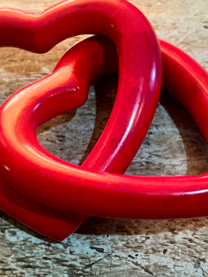 Red heart-shaped object on a wooden surface