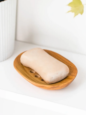 Bar of soap on a wooden soap dish with a white background