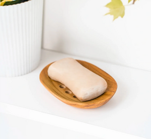 Bar of soap on a wooden soap dish with a white background
